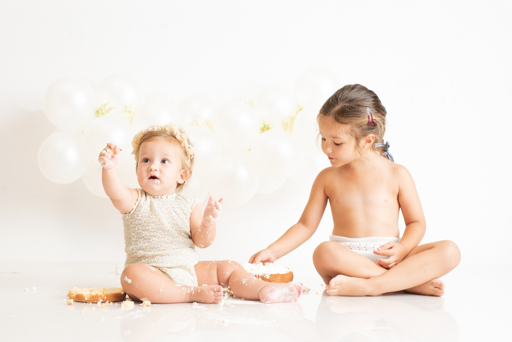 Fotografía de primer cumpleaños con su hermana mayor